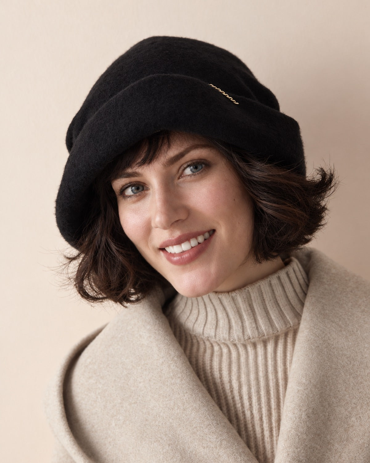 White female model wearing the Classic Black wool slouchy beret in a front smiling studio view