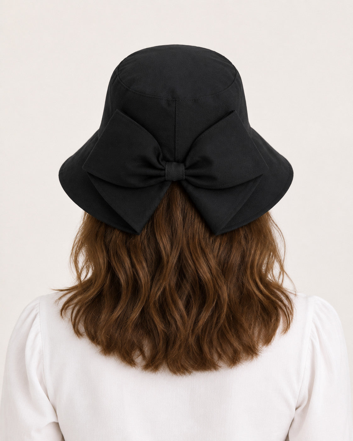 Rear view of woman wearing black bucket sun hat with oversized bow