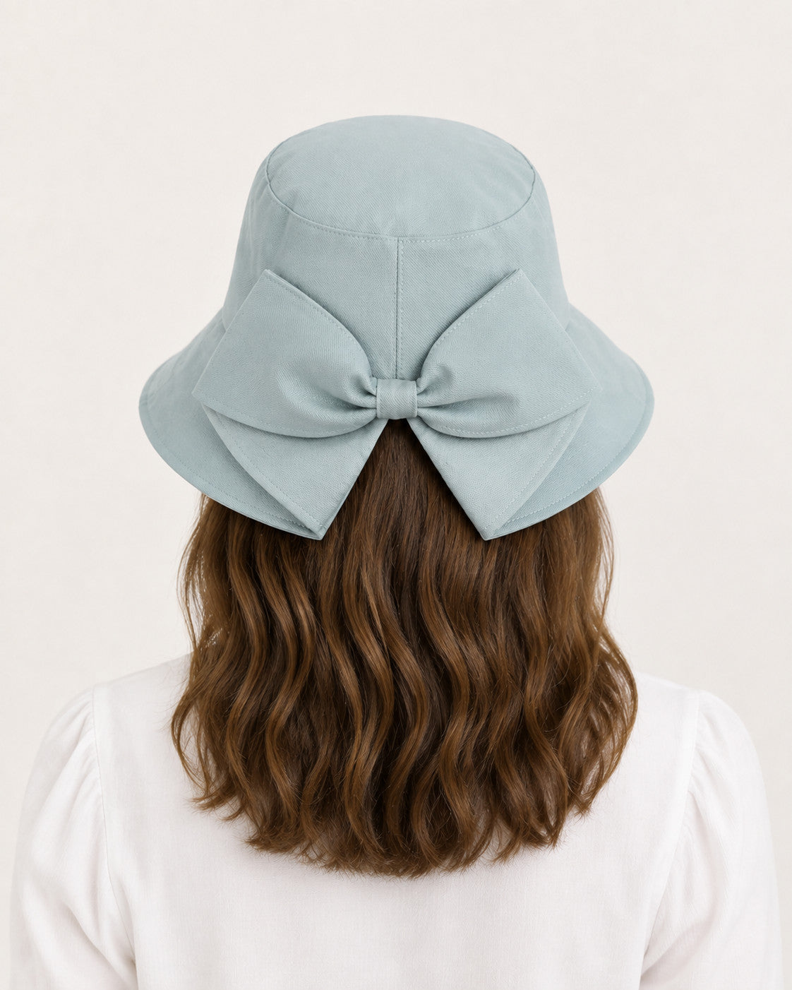 Rear view of woman wearing blue bucket sun hat with oversized bow