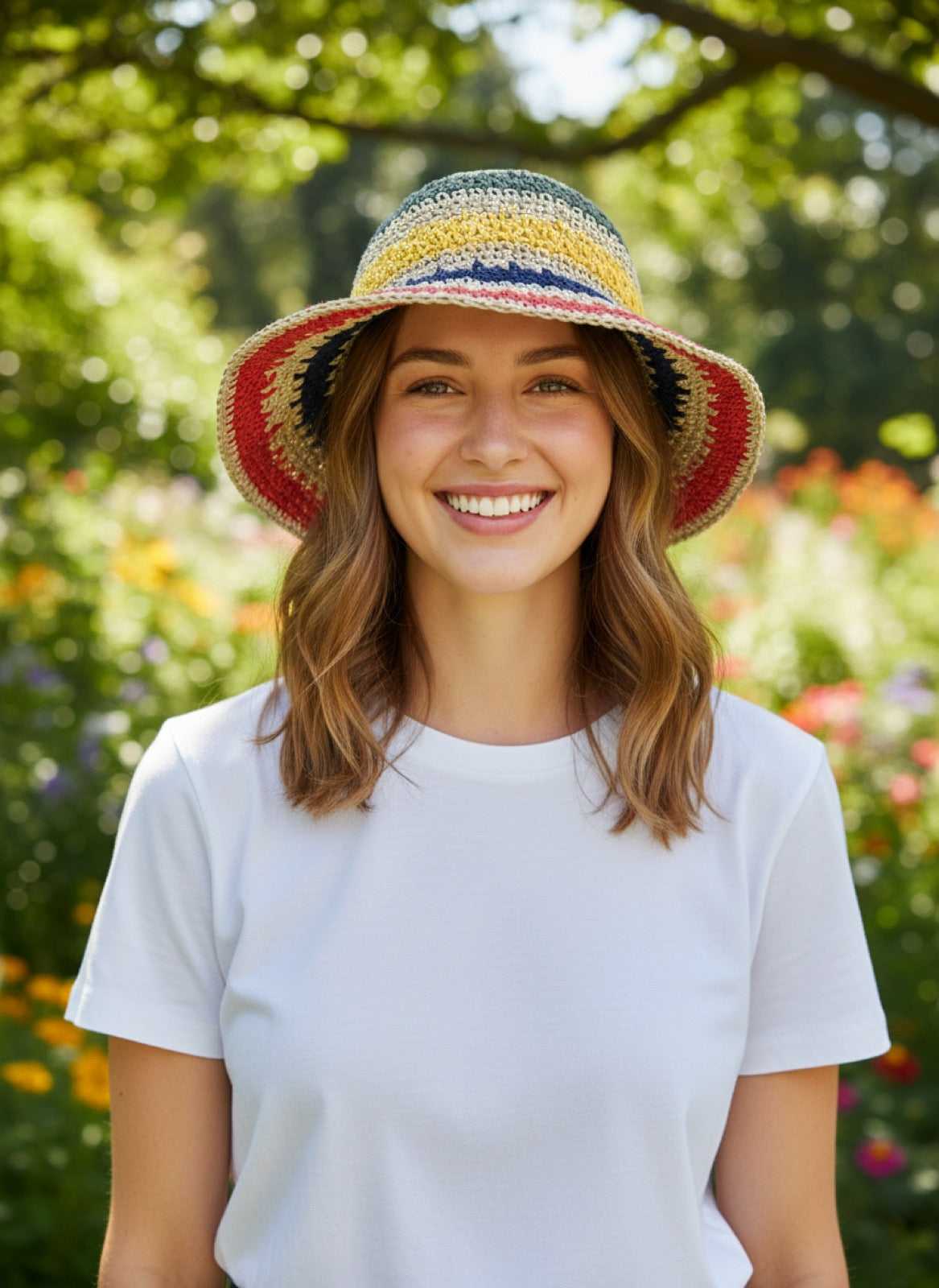 Woman wearing rainbow stripe straw bucket hat - front view in garden