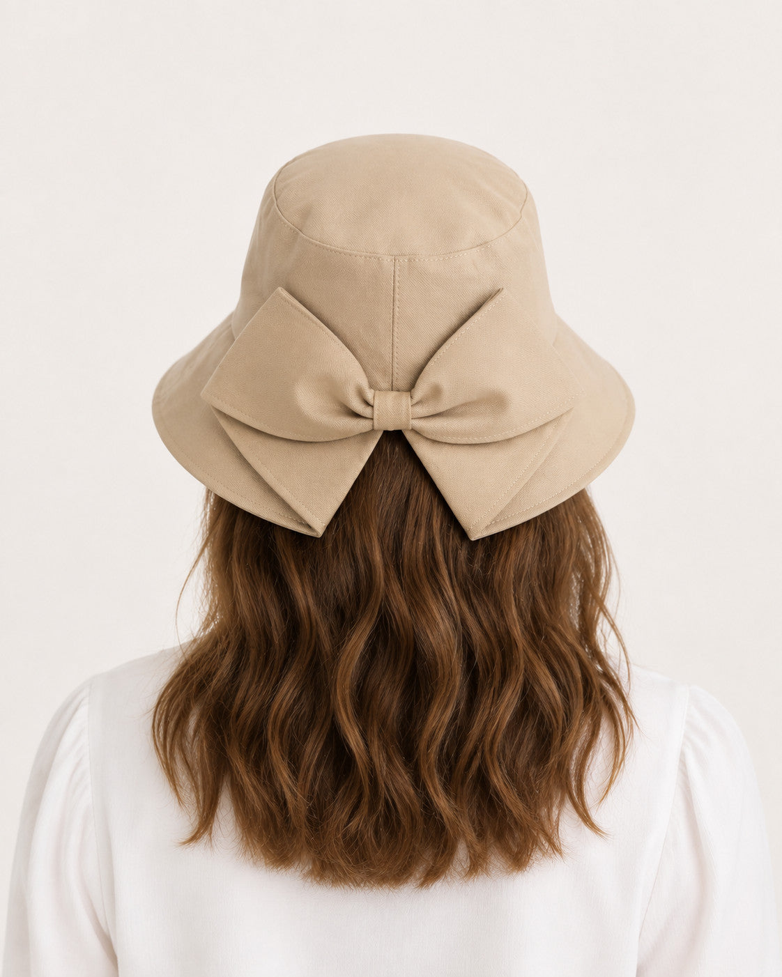 Rear view of woman wearing camel bucket sun hat with oversized bow