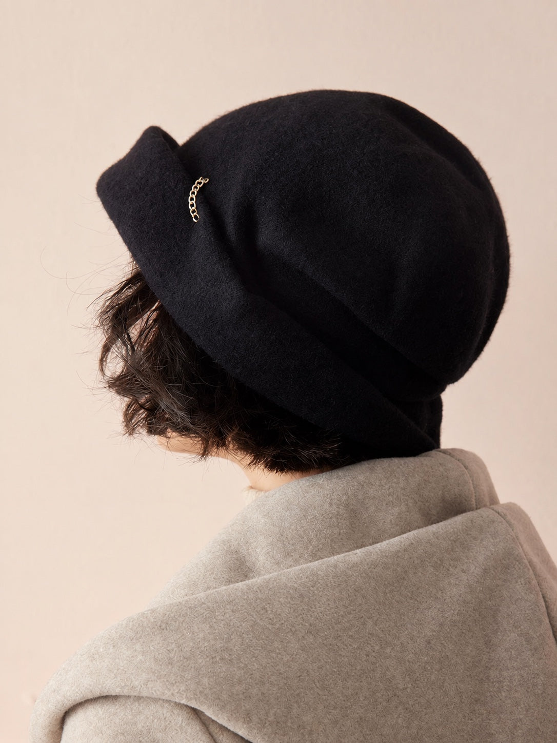 Woman wearing the Classic Black wool slouchy beret from a rear three-quarter view