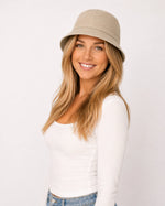 Woman wearing khaki cotton bucket hat, front view