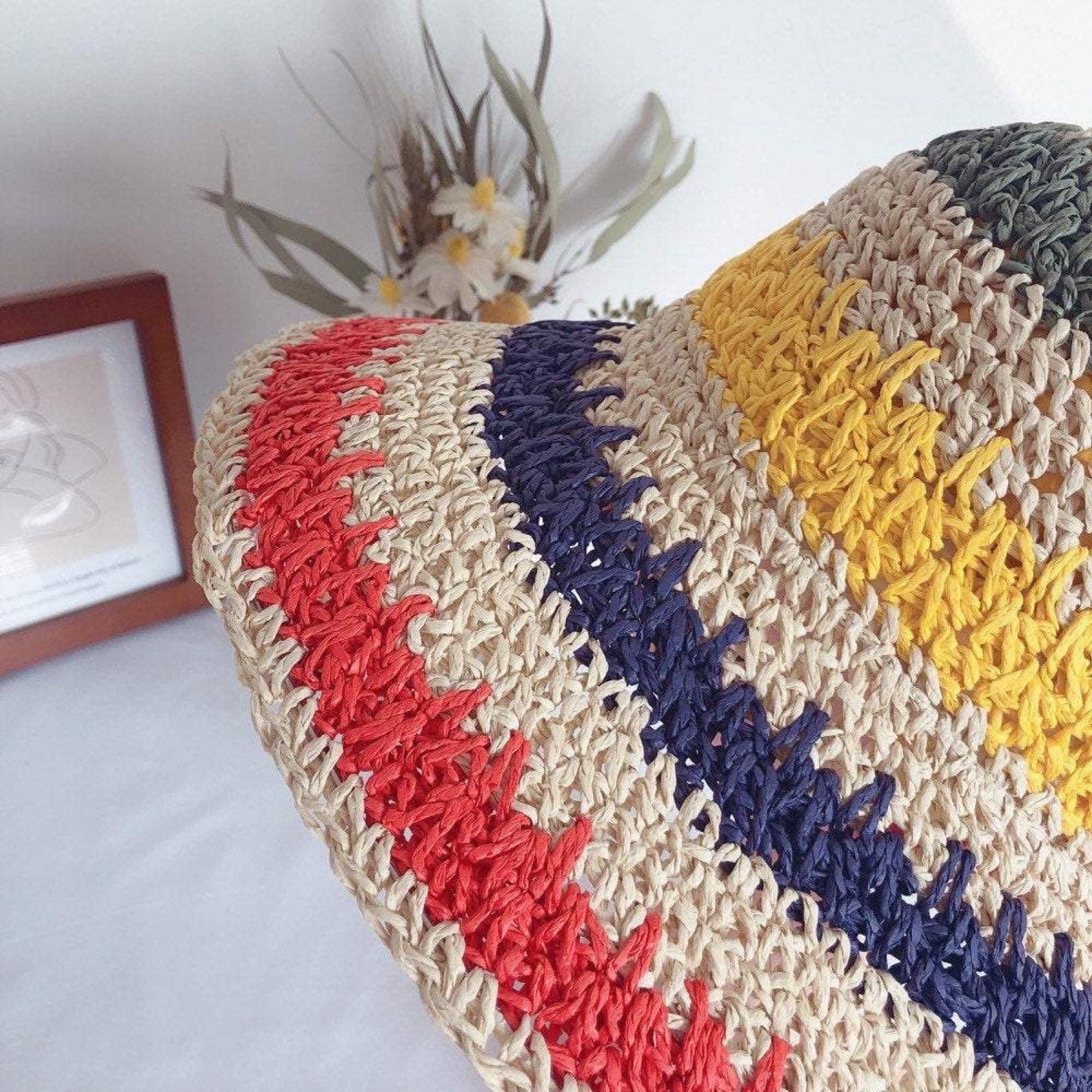Close-up of rainbow straw hat brim showing stripe pattern and weave