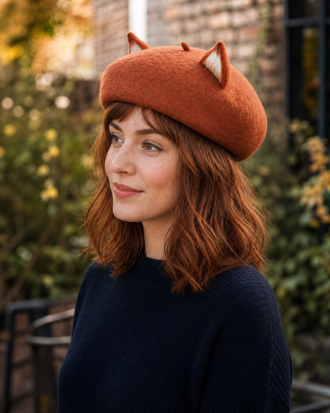 White model wearing the rust-brown wool fox-ear French beret in right profile