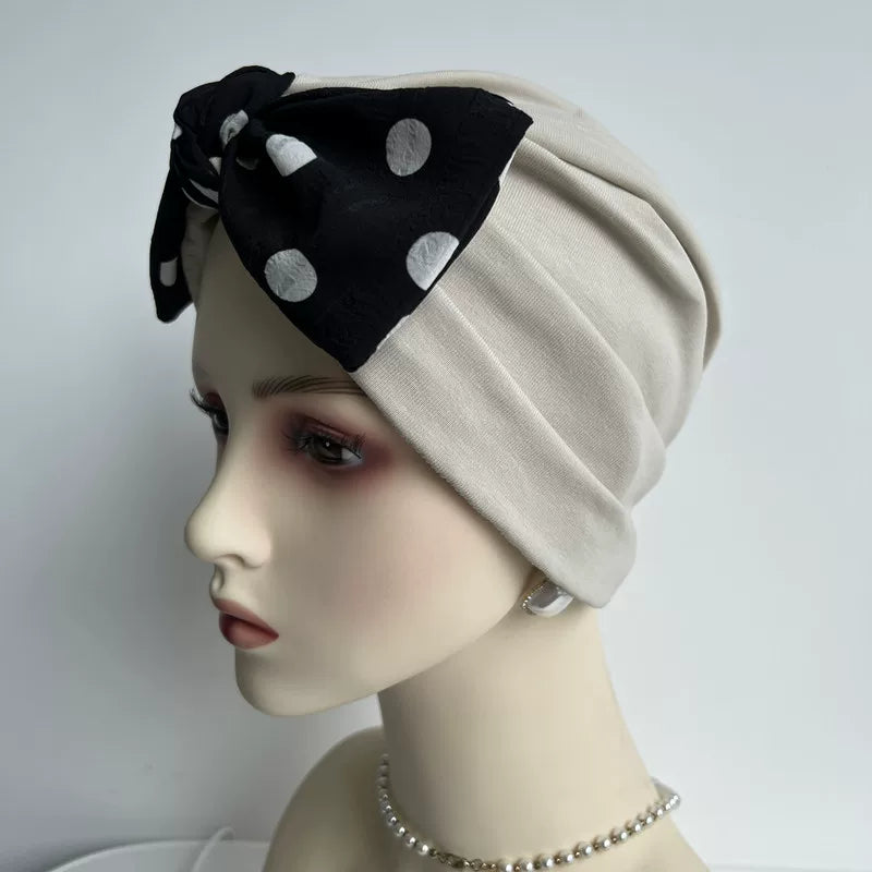 Khaki modal cotton turban hair wrap with black polka dot bow, angled view