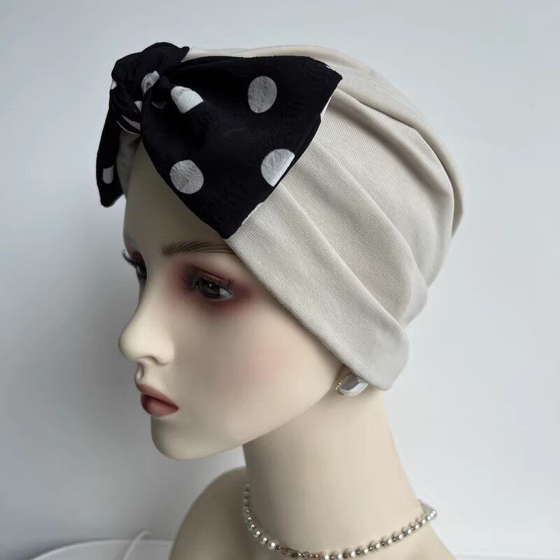 Khaki modal cotton turban hair wrap with black polka dot bow on mannequin