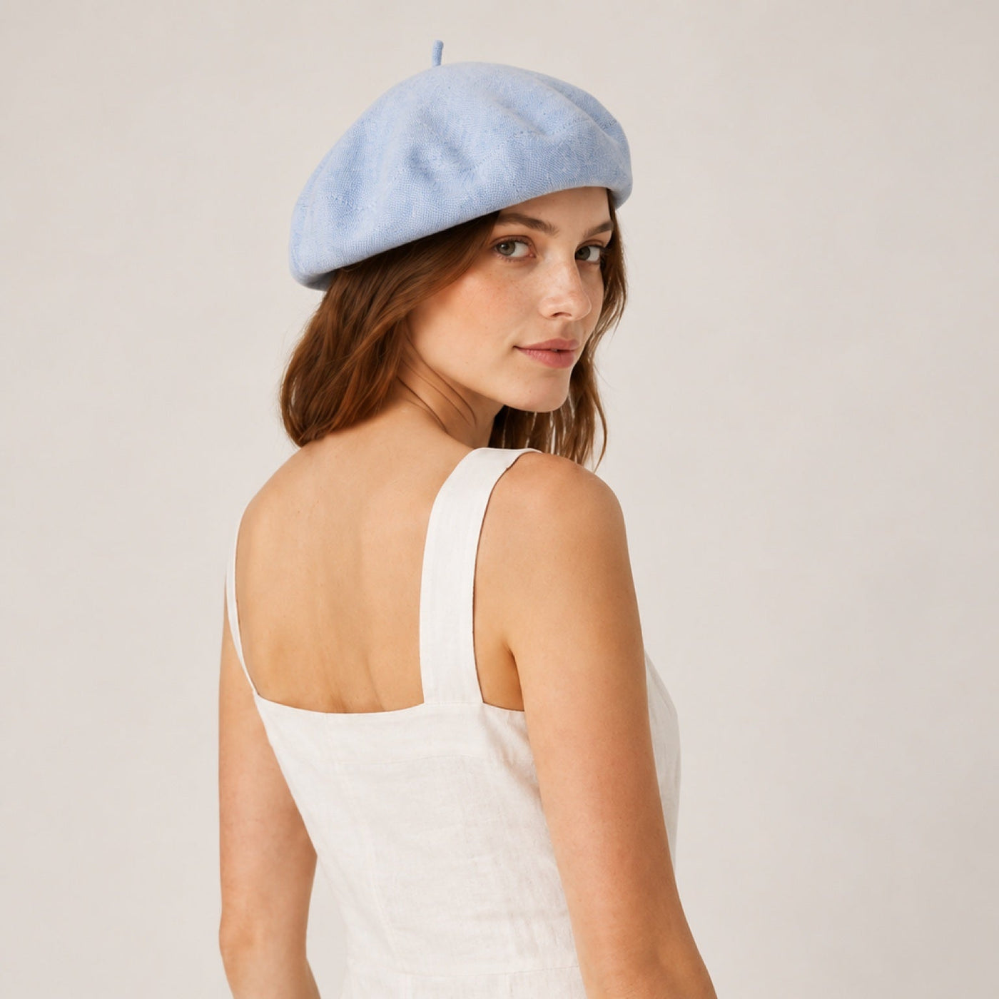 Woman wearing light blue linen beret