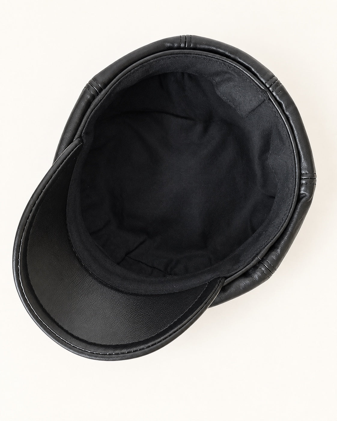 Interior of the black genuine leather newsboy cap showing its dark lining, inner band and underside of the brim