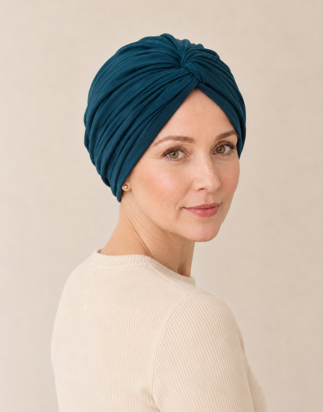 Woman wearing a peacock blue chemo-friendly modal cotton knot turban head wrap