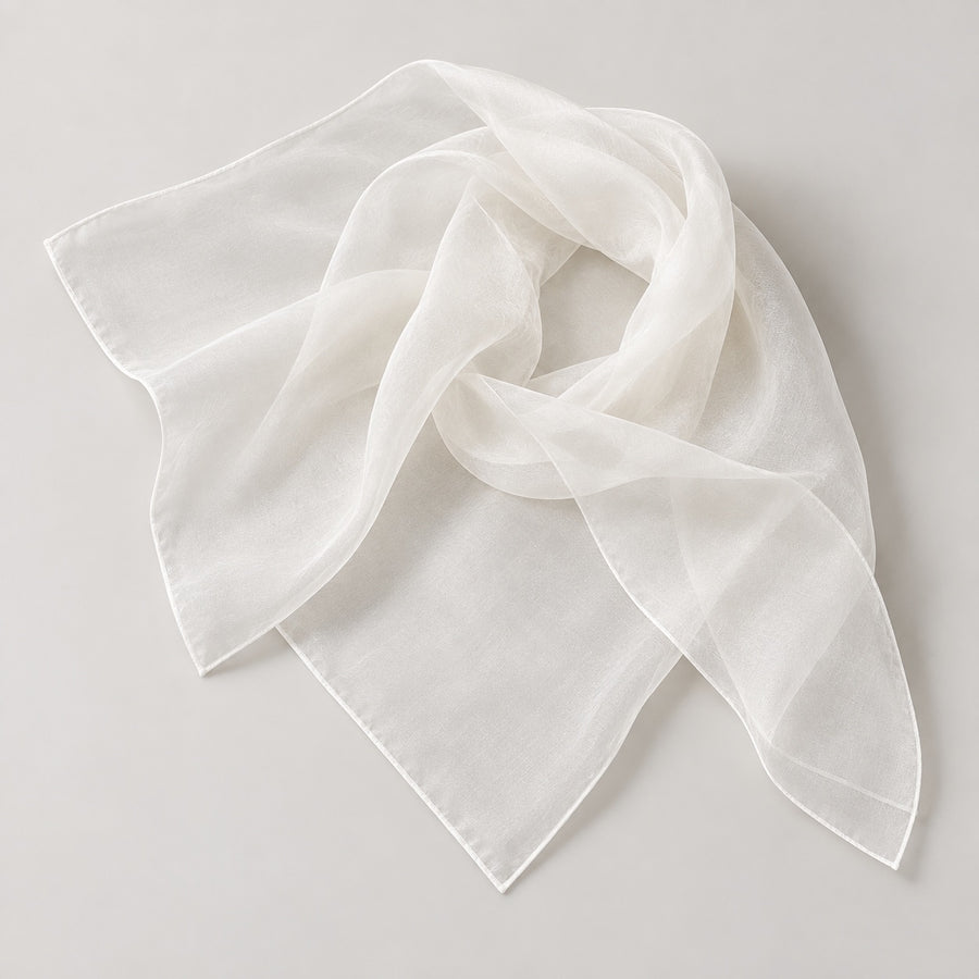 White sheer silk organza scarf arranged on a light gray studio background