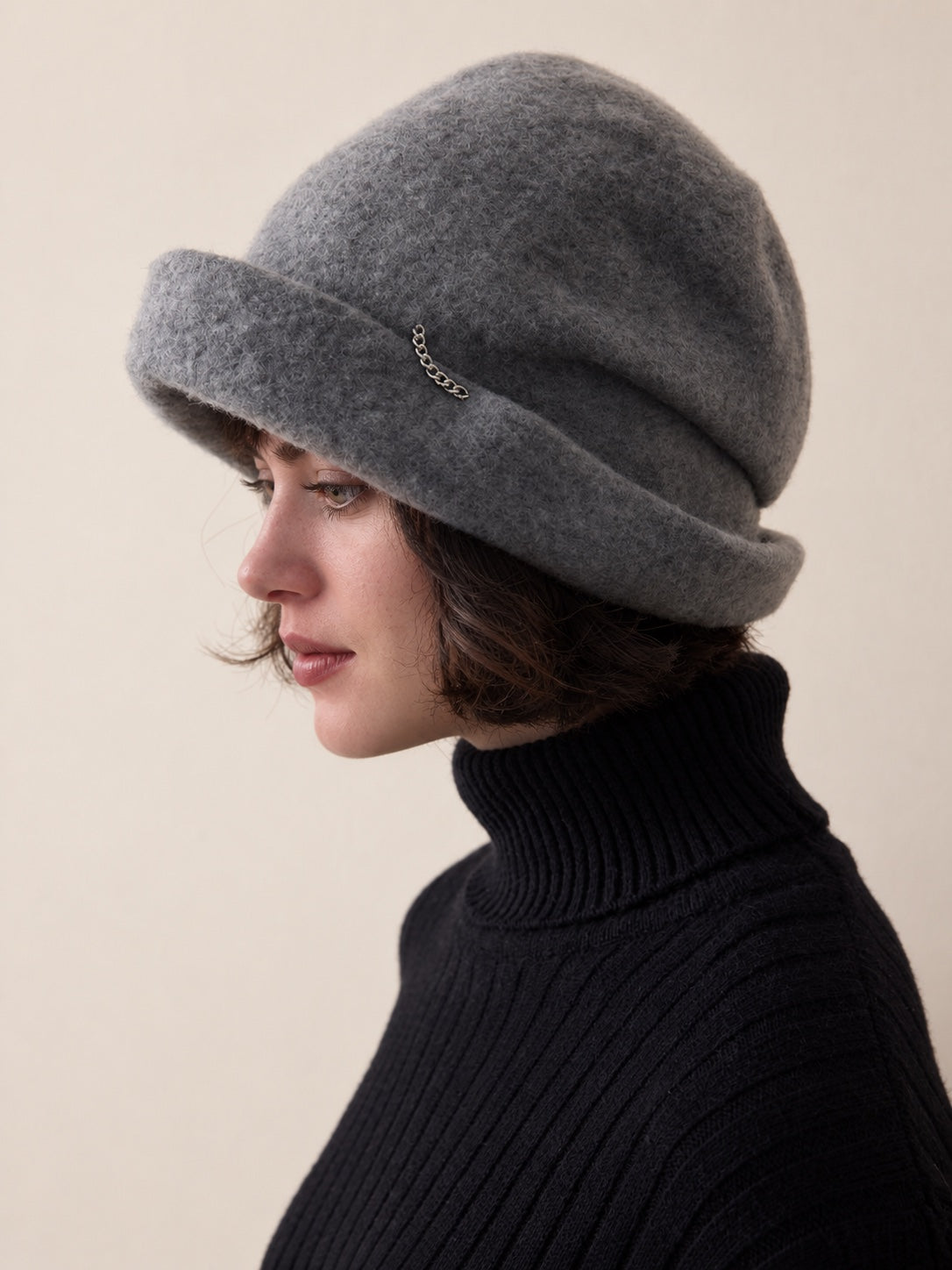 White female model wearing the Smoke Grey wool slouchy beret in a left side-profile studio view