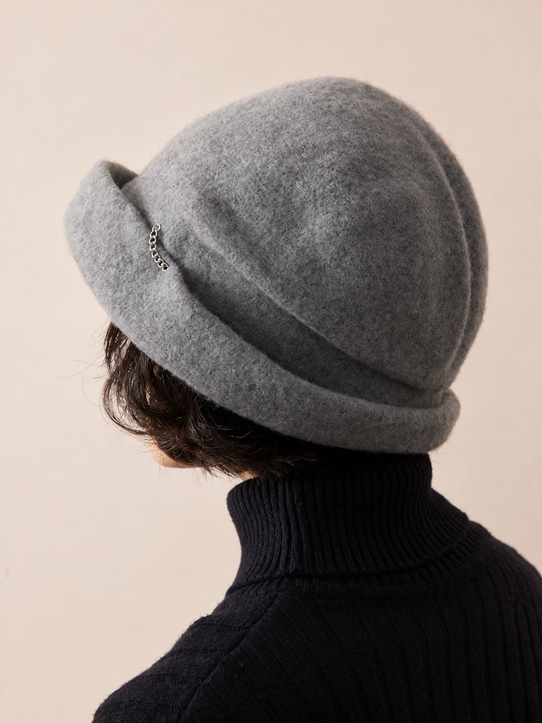 Woman wearing the Smoke Grey wool slouchy beret from a rear three-quarter view