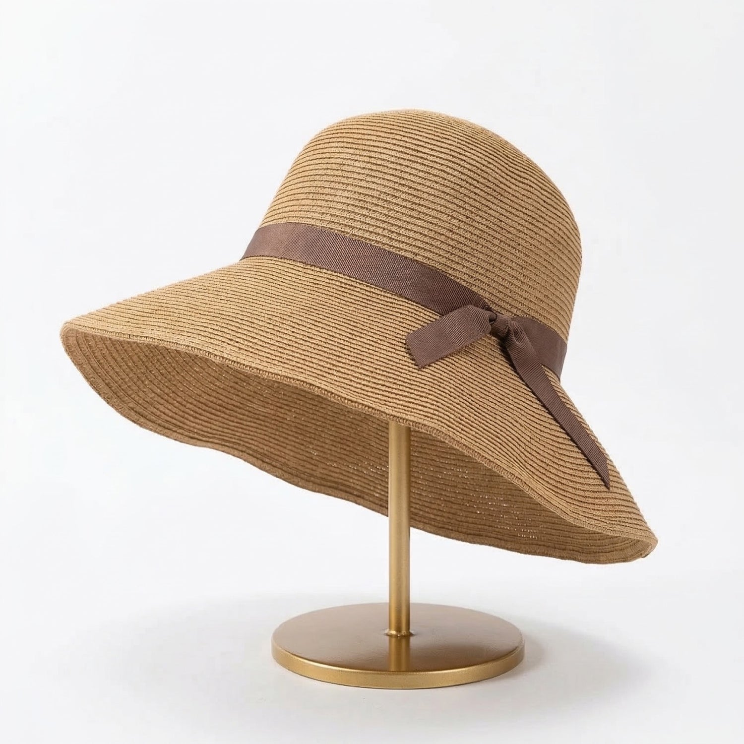 Foldable straw cloche hat with brown ribbon bow on display stand