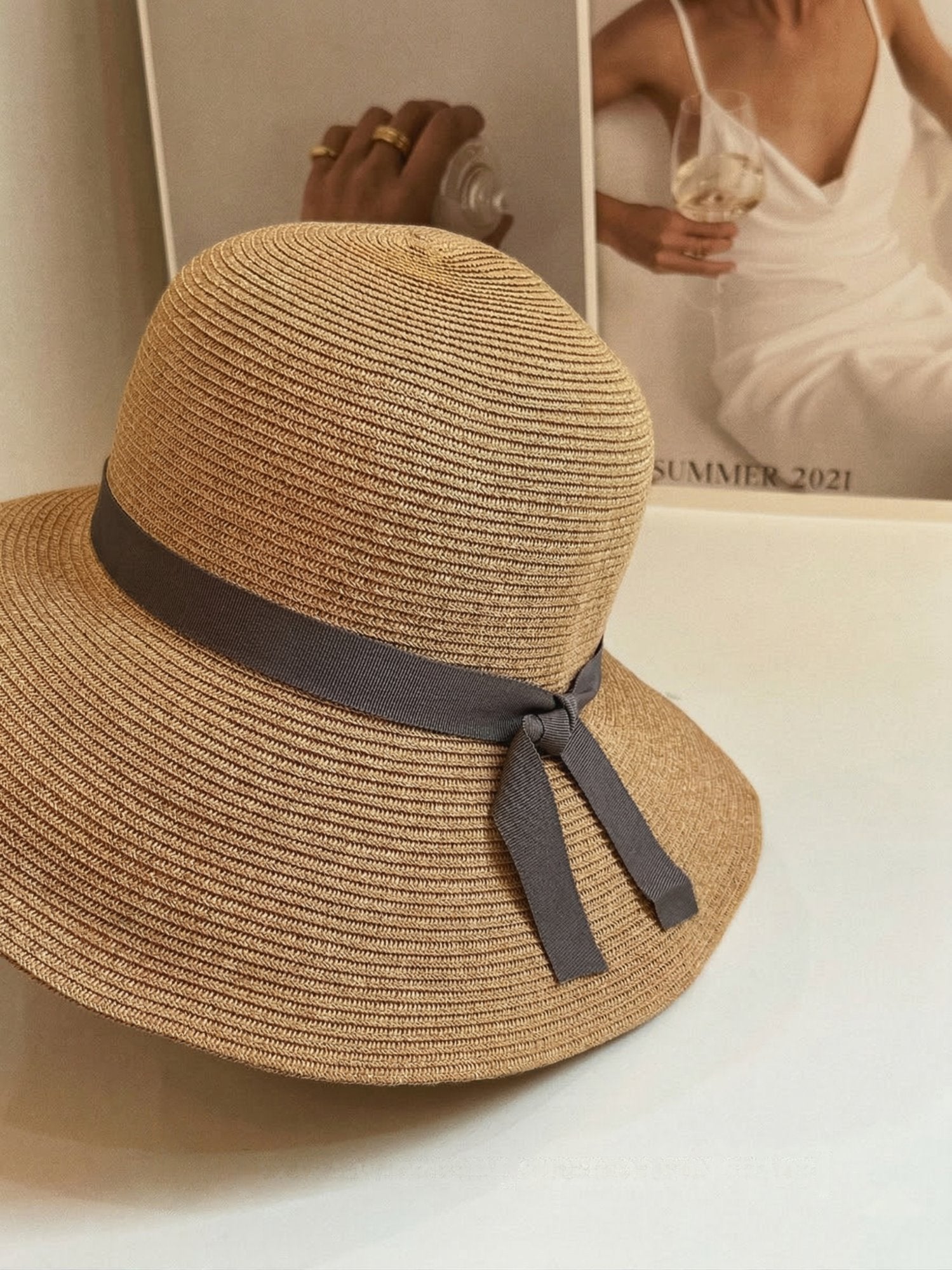 Close-up of straw cloche hat with grey ribbon bow detail
