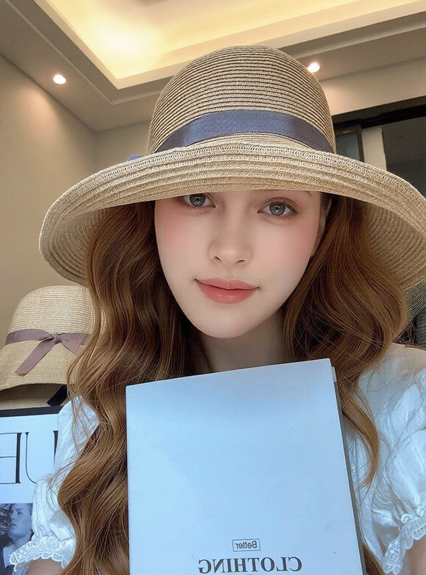 Woman wearing straw cloche sun hat with grey ribbon bow