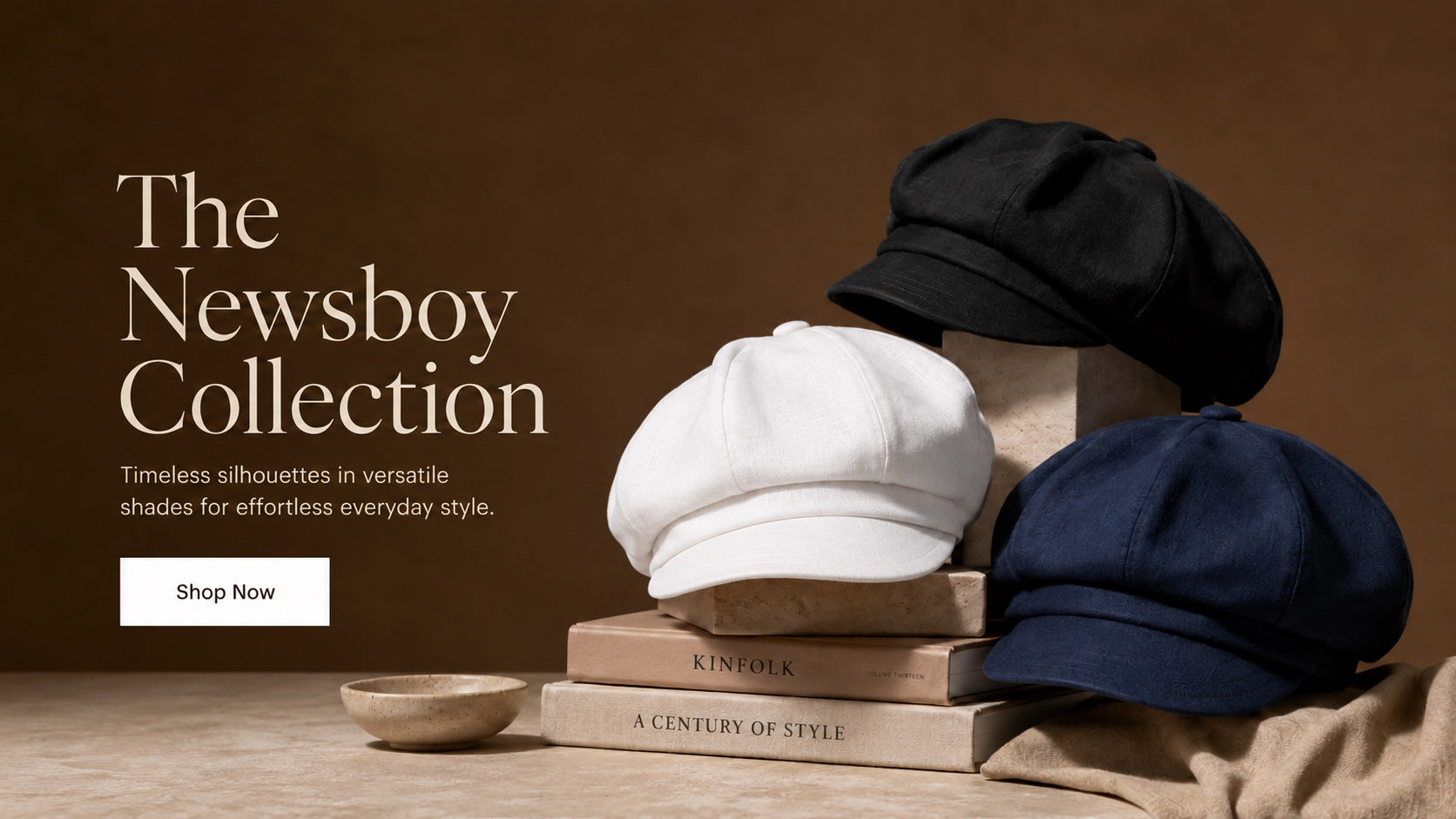 Black, white, and navy newsboy caps displayed on warm neutral blocks