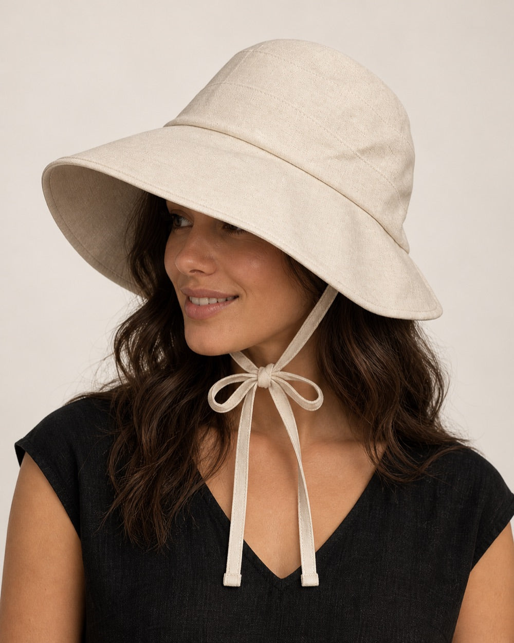 Close view of the linen texture, crown seams, bound brim, and tied bow