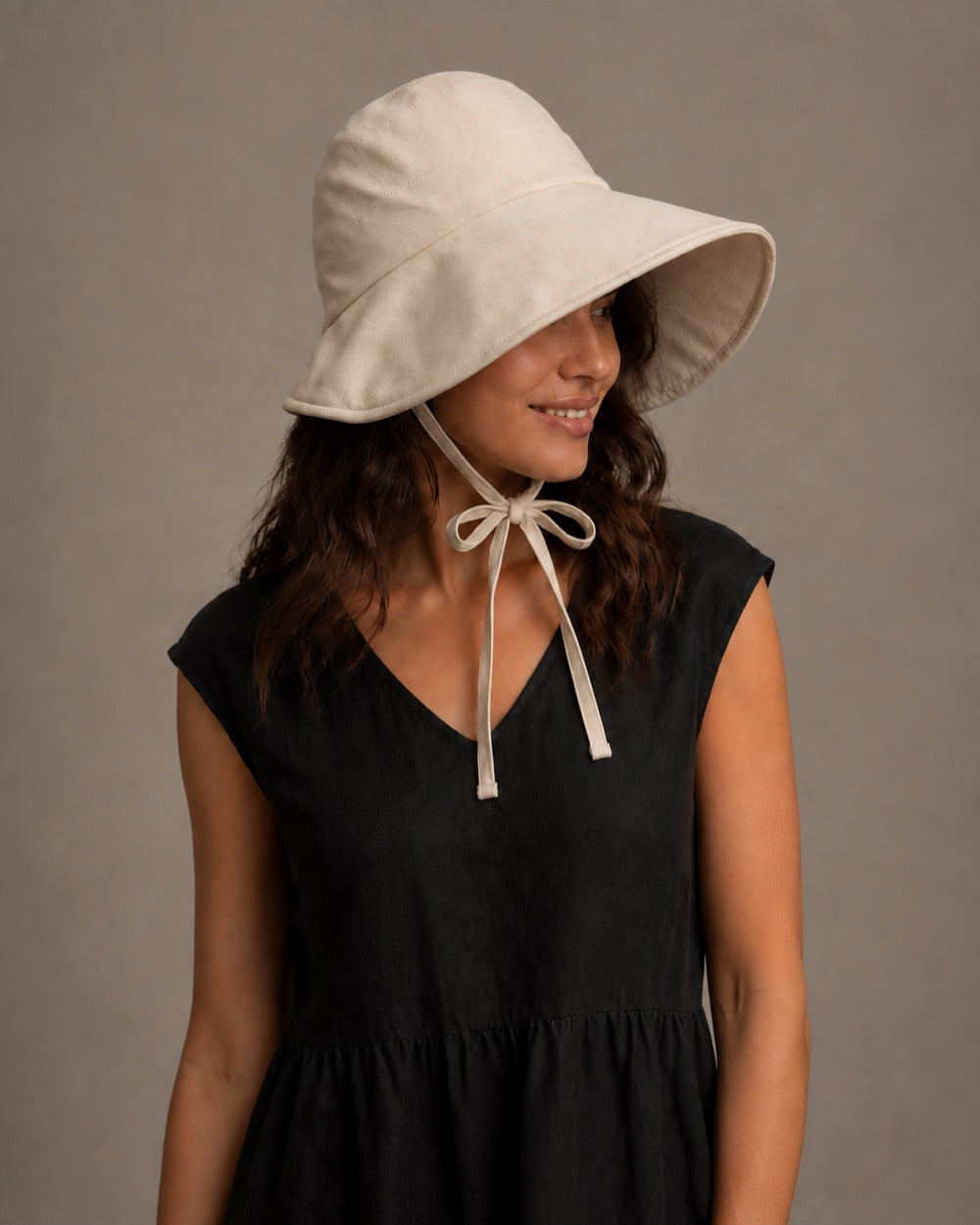 Near-front view showing the brim coverage and chin ties knotted in a bow