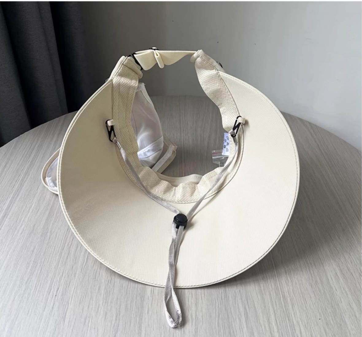 Inside view of the wide brim sun hat showing its adjustable rear buckle and chin cord