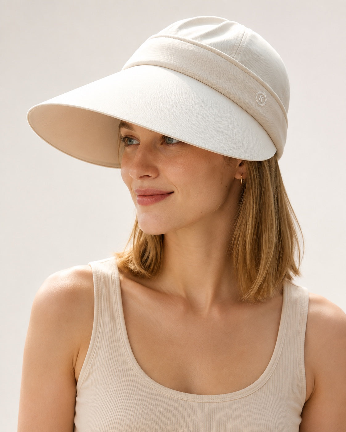 Woman wearing the beige wide brim sun hat with its removable crown attached